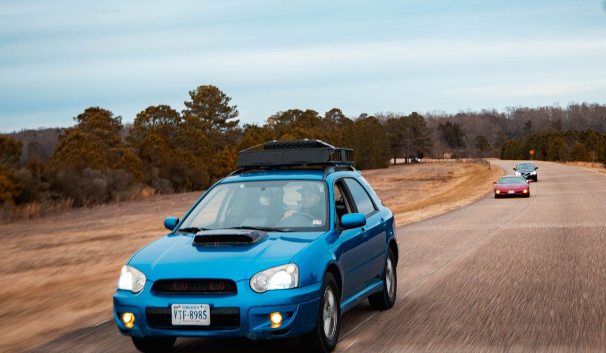 Car with roof rack driving on an open road, ready for a longer trip